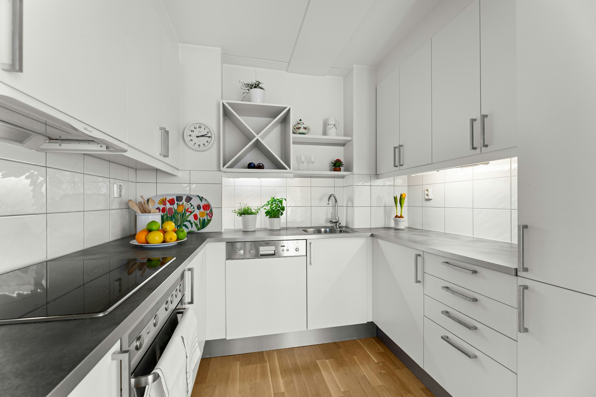A kitchen with white cabinets and black counter tops